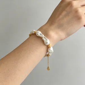 Detailaufnahme des unregelmässigen Perlenarmbands mit Metallverlängerungskette und Anhänger.