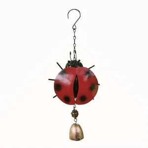 Close-up detail of the metal ladybug wind chime showing textured red body and hanging bell.