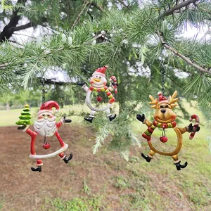 Detail shot of Christmas iron hanging ornaments with Santa, snowman and reindeer on pine tree.