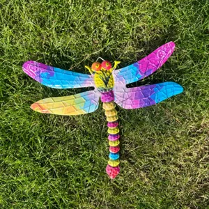 Vista dettagliata di una libellula in metallo colorato sospesa per decorare il giardino.
