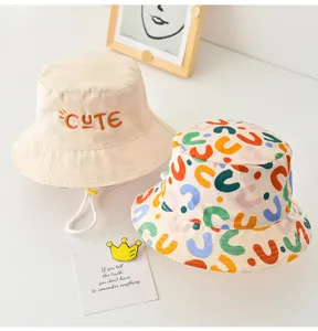Detail shot of reversible kids bucket hat, cute embroidery and colorful print design for summer.