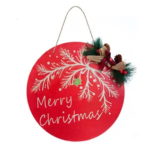 Detailed view of round wooden Christmas hanging plaque with festive pine branch and bow decor.