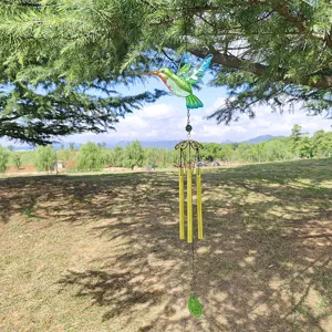 Outdoor hanging metal hummingbird wind chime detail, colorful glass tubes in park.
