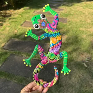 Close-up detail of colorful metal gecko wall art, vibrant painted outdoor garden decoration.