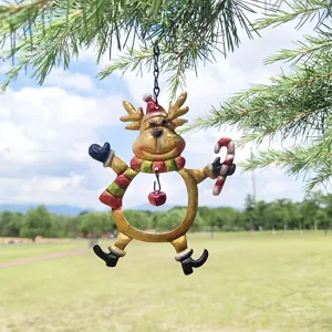 Detailed shot of the painted iron Christmas reindeer ornament hanging outdoors on pine tree.