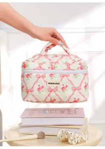 Quilted cosmetic bag with pink ribbon and rose floral print, portable makeup pouch for women.