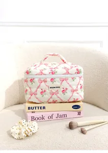 Quilted cosmetic bag with pink bow and rose pattern, elegant portable makeup organizer detail view.