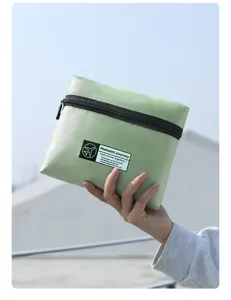 Bolsa de viaje plegable en verde claro con patrón de rombos y cremallera negra resistente.