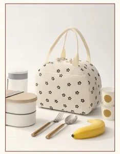 Vue détaillée du sac à lunch en velours côtelé à fleurs avec poignées pour le pique-nique.