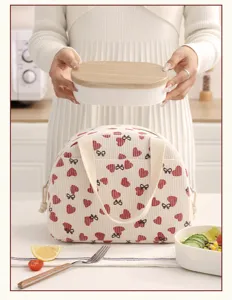 Détail du sac à lunch en velours côtelé avec motif de cœur et nœud pour un usage quotidien.