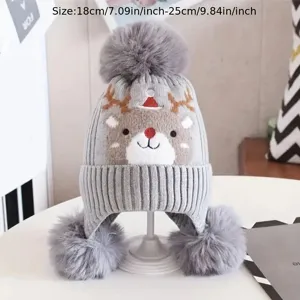 Detailed view of grey kids winter knitted hat featuring cute reindeer and fluffy pom-poms.