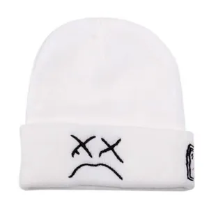 White knit beanie for winter, featuring embroidered sad face and XX eyes design for streetwear style.