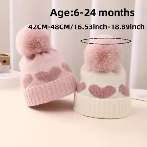 Baby winter knit hat detail, cute heart pattern with soft pom-pom, warm and comfortable for kids.