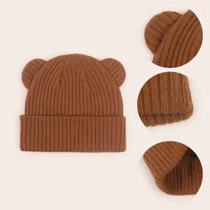 Infant cute bear ear knit beanie hat detail view, soft warm winter baby wool cap texture.