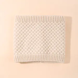 Dettaglio scaldacollo in maglia, morbida trama beige di snood invernale primo piano, collo termico.
