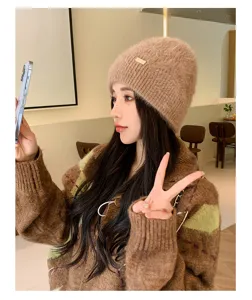 Detail view of the cozy knitted winter beanie hat worn by model, soft plush texture for warmth.