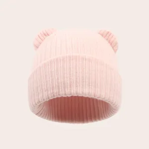 Close up of pink baby knit beanie with cute bear ears, soft stretch winter warm hat.
