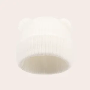 Cute white infant bear ear knit hat detail view, soft autumn winter warm baby beanie cap.