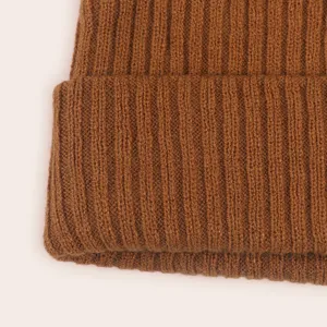 Close-up detail of brown ribbed knit baby beanie hat, showing soft texture and fine stitches.