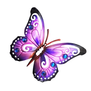 Close-up detail of purple metal butterfly wall decor with blue rhinestones and cutout patterns.