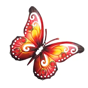 Detail shot of the metal butterfly wall art with cutout patterns and red jewel design.
