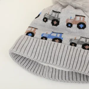 Grey children knitted winter beanie hat with cute tractor patterns and fluffy pom pom.