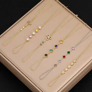 Primer plano de pulseras de mano de moda con circonitas de colores y diseño de trebol.