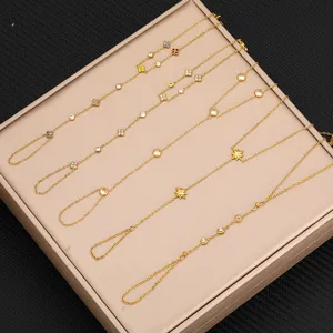 Bracciale da mano in acciaio titanio dorato con ciondoli trifoglio e stella in zircone lucido.