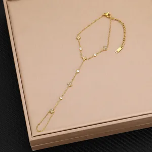 Bracciale da mano in acciaio al titanio dorato con motivi a trifoglio in zirconia cubica.