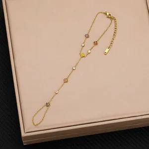 Squisito bracciale da dito dorato con trifogli in zirconia cubica colorati e pietre tonde.