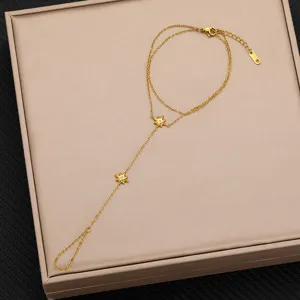 Primo piano dettagliato del bracciale da mano in acciaio dorato con stelle e zirconi.