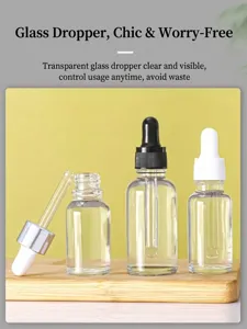 Close-up of 30ml transparent glass essential oil bottles with droppers on wooden base