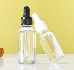 Detailed view of 30ml transparent glass dropper bottles with black and white caps