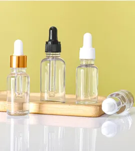 Detailed view of clear glass dropper bottles with gold black and white caps