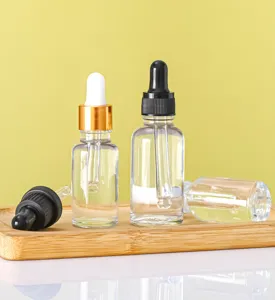 Detailed view of 30ml clear glass dropper bottles for essential oils on a natural bamboo tray