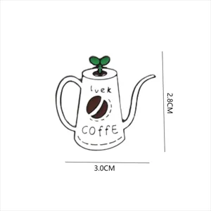 Detailed view of the cute coffee pot shaped enamel pin with green sprout and coffee bean.