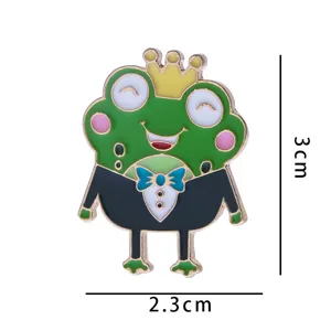 Gros plan détaillé de la jolie broche grenouille verte avec couronne et costume, émail métallique.