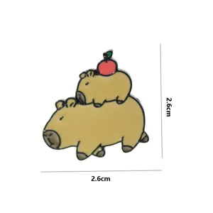Cute capybara apple metal brooch pin detail view, fashion backpack clothing accessory.