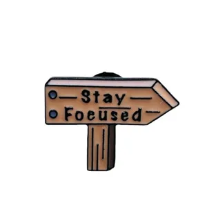 Cute enamel pin with Stay Focused text design, perfect for decorating clothes and bags.