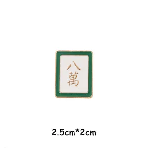Mahjong tile enamel brooch detail view, green and white metal badge, 2.5cm size.