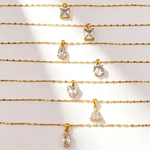 Vue détaillée de colliers en acier inoxydable plaqué or avec des pendentifs géométriques.