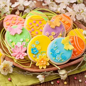 Closeup detail of colorful decorated Easter egg cookies with icing flowers and butterflies.