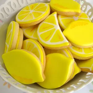 Lemon shaped sugar cookies with bright yellow icing, perfect for baking displays and parties.