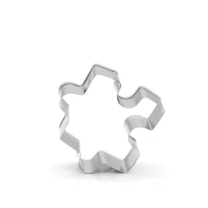 Stainless steel puzzle piece cookie cutter for fondant baking and kitchen styling tools detail.
