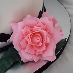 Close-up detail of large pink fondant rose cake decoration, showing exquisite sugar flower texture.