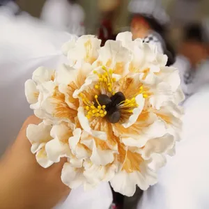 Handcrafted white peony sugar flower cake decoration with detailed petals and bright yellow center.