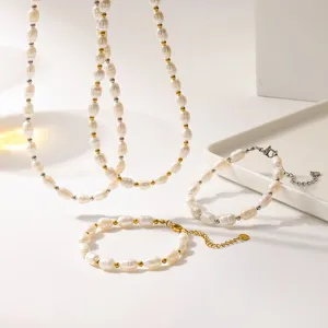 Primo piano di un set di collane e bracciali in perle d'acqua dolce naturali con perline dorate.