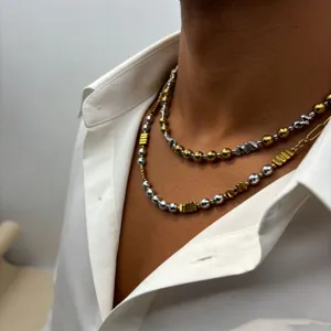 Vue détaillée du collier ras de cou multicouche en perles dorées et argentées en acier.