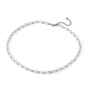 Dettaglio della collana di perle d'acqua dolce con perle bianche e piccole sfere metalliche.