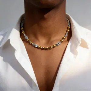 Gros plan détaillé d'un collier de chaînes de perles métalliques et dorées style.